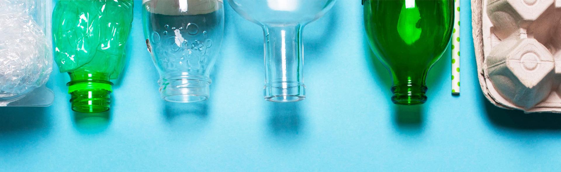 Emballager af plast, glas og pap ligger på blå bord
